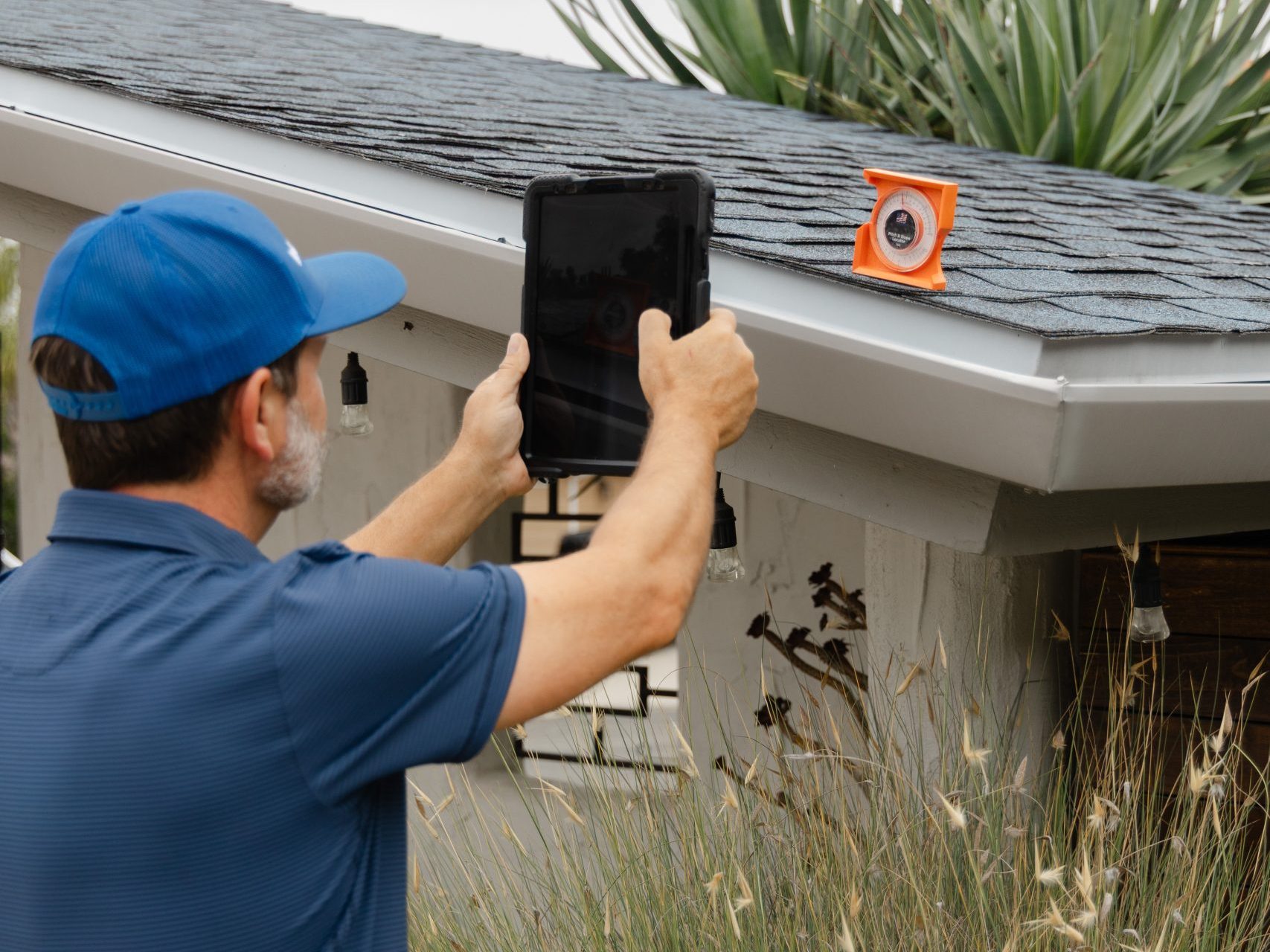 roof inspection guy using camera to measure slope